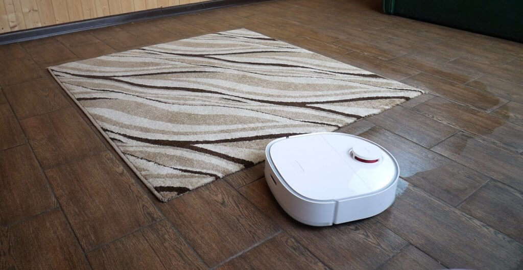 Un aspirateur robot se déplace sur le tapis